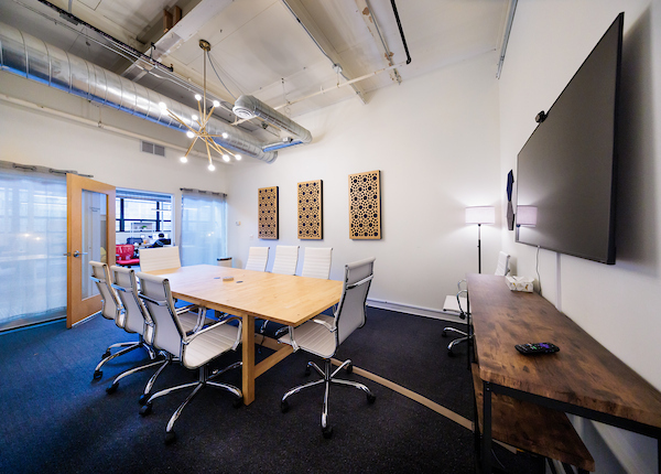 Large conference room with wall-mounted TV at Platform Coworking